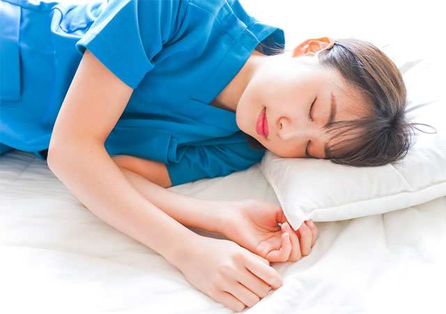 青い服を着た女性の寝ている姿